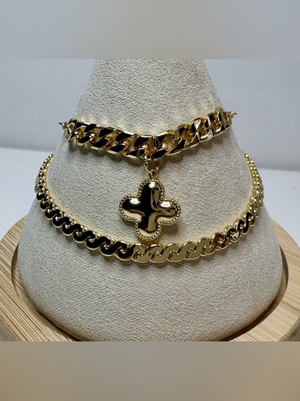 Two 18k gold filled bracelets with cuban style chains, and a clover pendant.